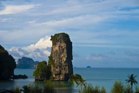 a tall large rock in the water