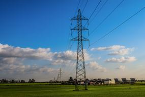 High Voltage Pylon among a green field on a summer day