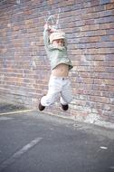 Child boy Jumping at brick wall