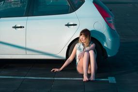 girl sitting near the car