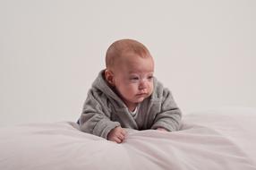 Cute lying baby on the white blanket