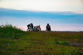 motorcycle and biker on a hill against a blue sky