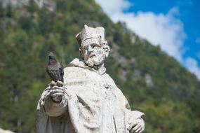 a dove sits on a stone statue