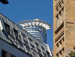 upper floors of a glass skyscraper in Frankfurt and other buildings at blue sky background