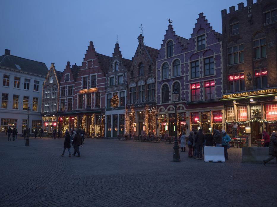 People, near the beautiful and colorful buildings, with the colorful lights, in the Bruges, Belgium, on the Christmas, in the evening