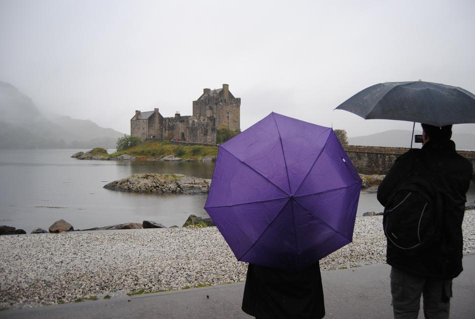 people standing on the beach with umbrellas