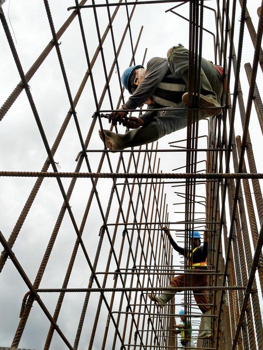 Indonesian workers on the construction, under the sky with dark clouds