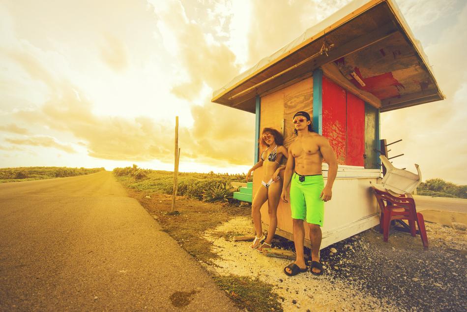young people stand in swimsuits at the edge of the road