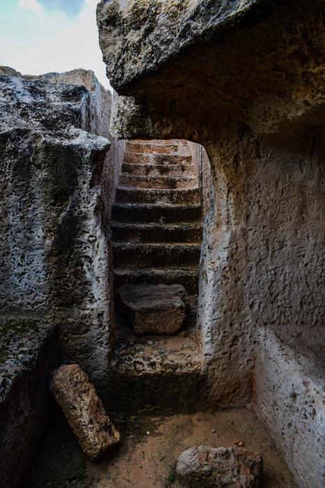a stone archway of ruins and stairs