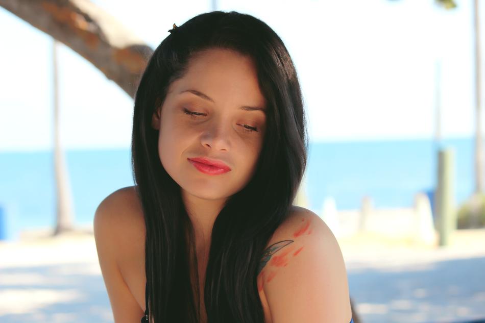 Girl posing on the beach at blue water background