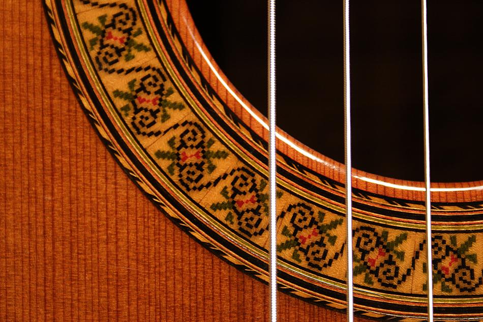 close up of the strings of a wooden guitar