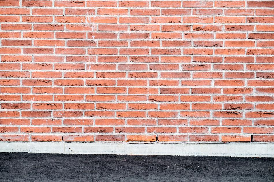 photo of a brick wall and asphalt r
