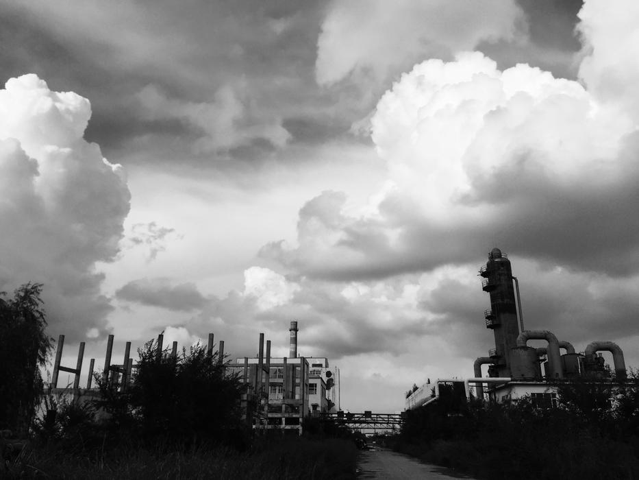 white clouds in the sky above the factory