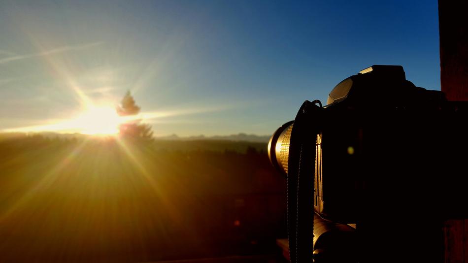 Camera on the background of the rising sun