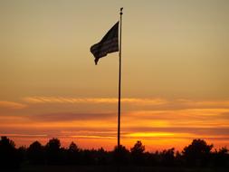 flag on a pole at sunset