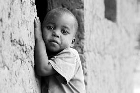 serious african child boy at stone wall, Uganda
