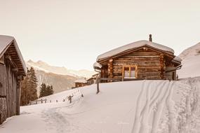 picturesque log cabins on snowy mountain side, Switzerland