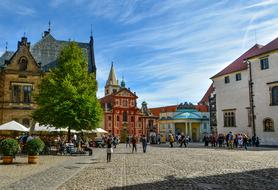 People, near the beautiful square, among the colorful and beautiful buildings and plants, in light, in Prague, Czech Republic