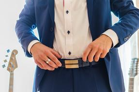 man in a beautiful suit with guitars in the background