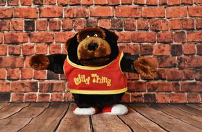 Soft toy baby on the background of a brick wall