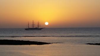 sailing ship against the sun