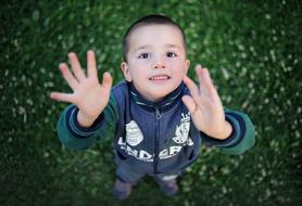 boy with raised arms close up