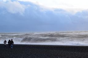 people walk on the beach by the sea