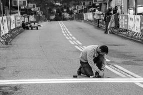 worker repairs the finish line on the highway