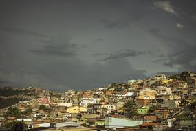panorama of a favela on a slope against a stormy sky