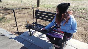 Girl and Squirrel on Bench in Park