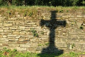 Shadow of cross on stone wall