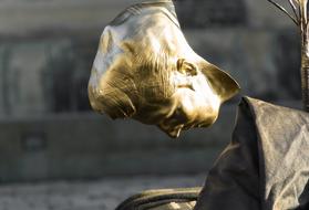 golden head sculpture on the street