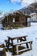 winter photo of the hut and garden table with benches