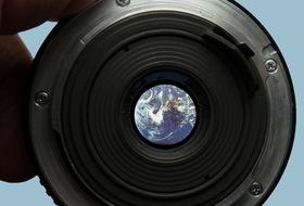black camera lens looking at the planet