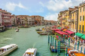 Beautiful landscape of Venice, with the canal with the boats, among the colorful buildings and people, in Italy