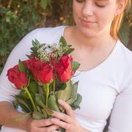 smiling girl with a bouquet of red roses