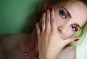 girl with blue eyes covered her mouth with her hand