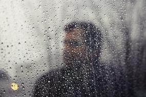 photo portrait of a man through a wet window