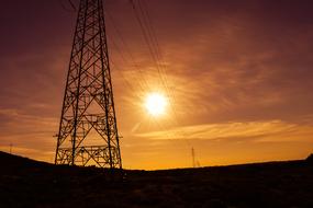 Electricity power line, with the pylon, at the colorful and beautiful sunset in the sky