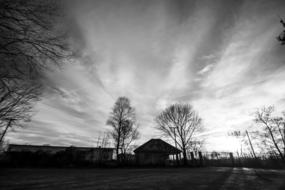 black and white photo of a field in front of an abandoned factory