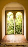 Beautiful view on the colorful trees, through the window in the beautiful Alhambra Palace in Granada, Spain