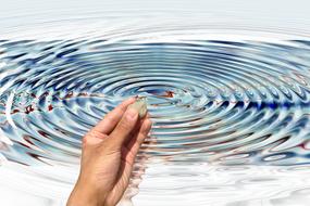 hand with a rock against a background of splashing water