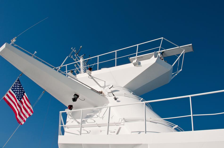 a white ship with a flag on a blue background