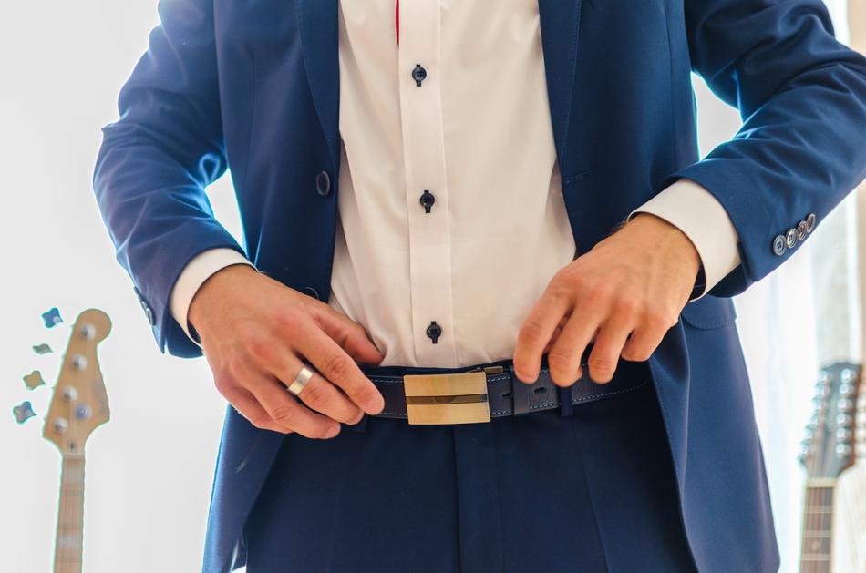 man in a beautiful suit with guitars in the background