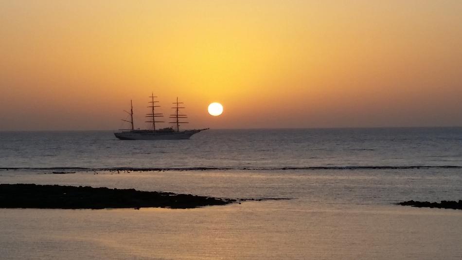 sailing ship against the sun