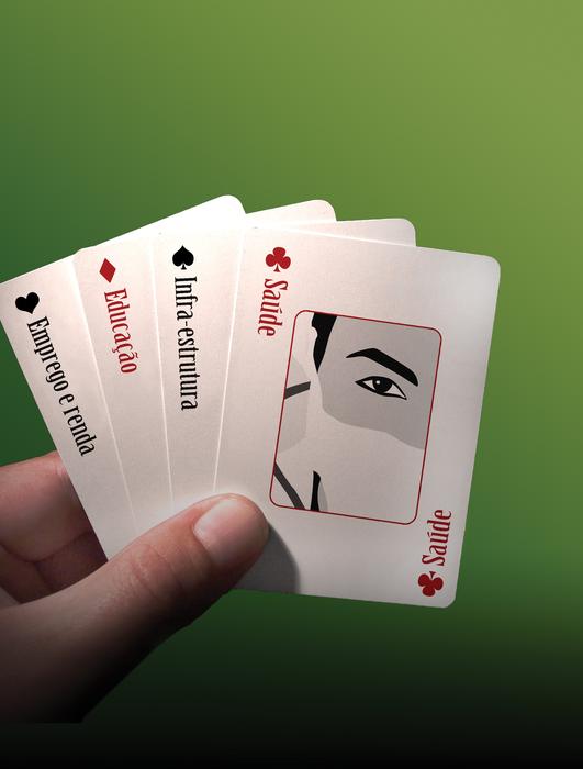 Red, black and white game cards in the hand at green background