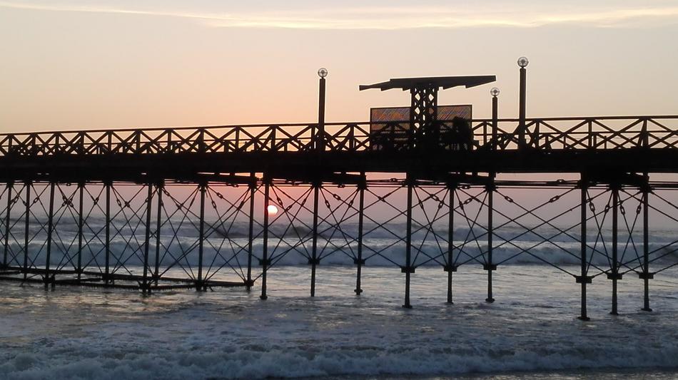 iron bridge with the sea with a house