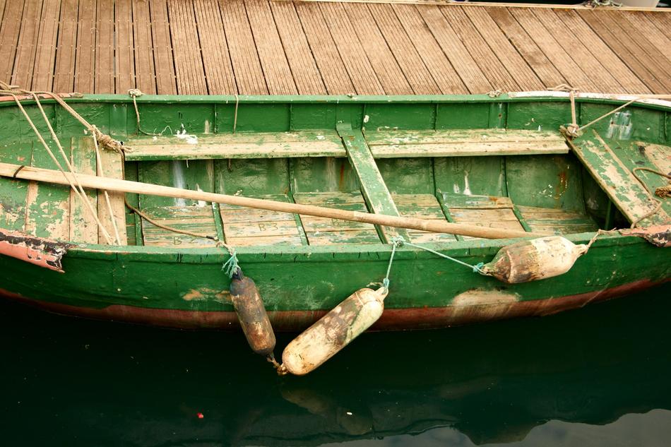 green fishing boat near the bridge