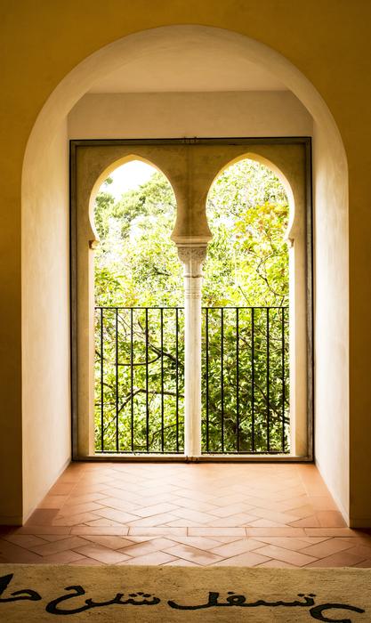 Beautiful view on the colorful trees, through the window in the beautiful Alhambra Palace in Granada, Spain