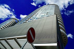 Shiny tower with the windows, in light, under the blue sky with white clouds